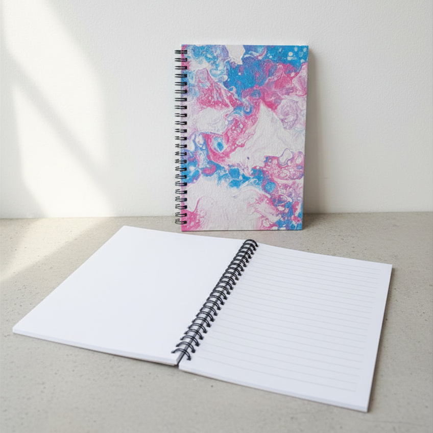 Notebook with a colorful trans pride cover on a light surface
