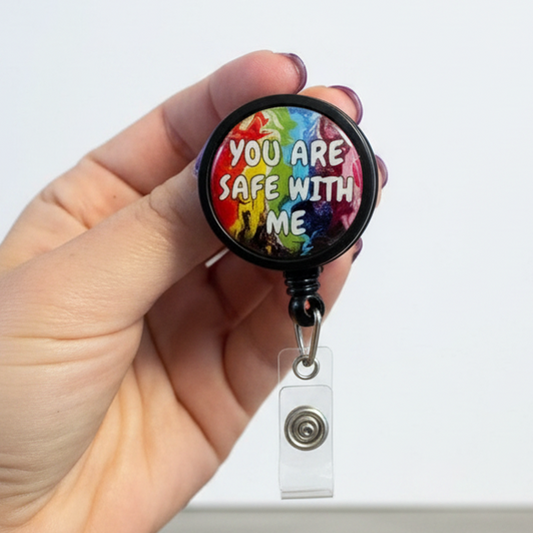 Hand holding a badge reel with a colorful message against a white background