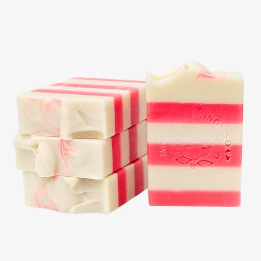 Bars of soap with a candy cane pattern, featuring red and white stripes and peppermint specks.