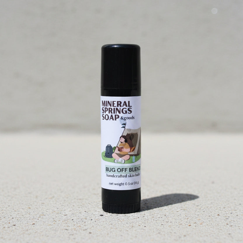 Roll-on stick of Mineral Springs Soap & Goods Bug Off Blend on a concrete photo backdrop surface