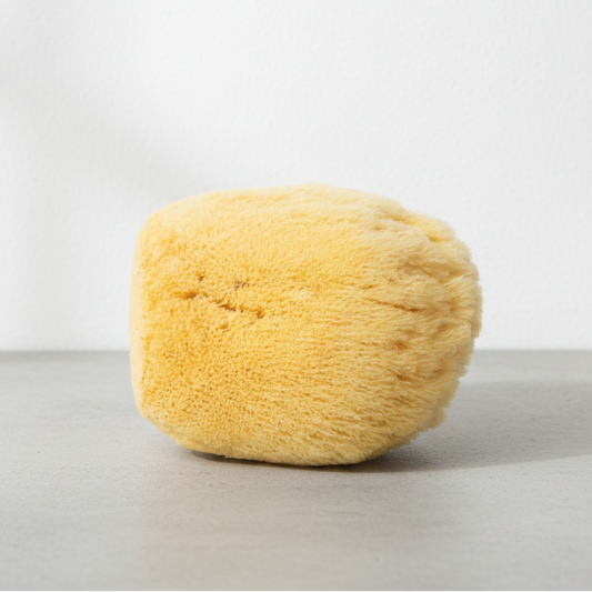 Yellow sponge on a gray surface with a white background