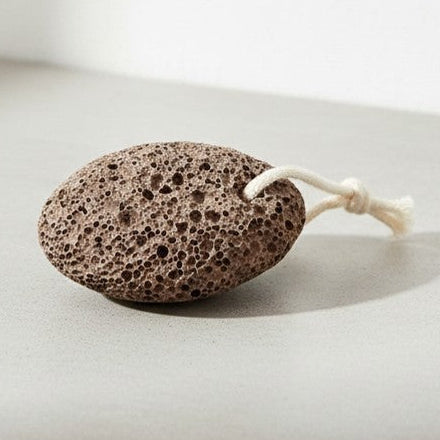 Brown pumice stone on a light concrete surface 