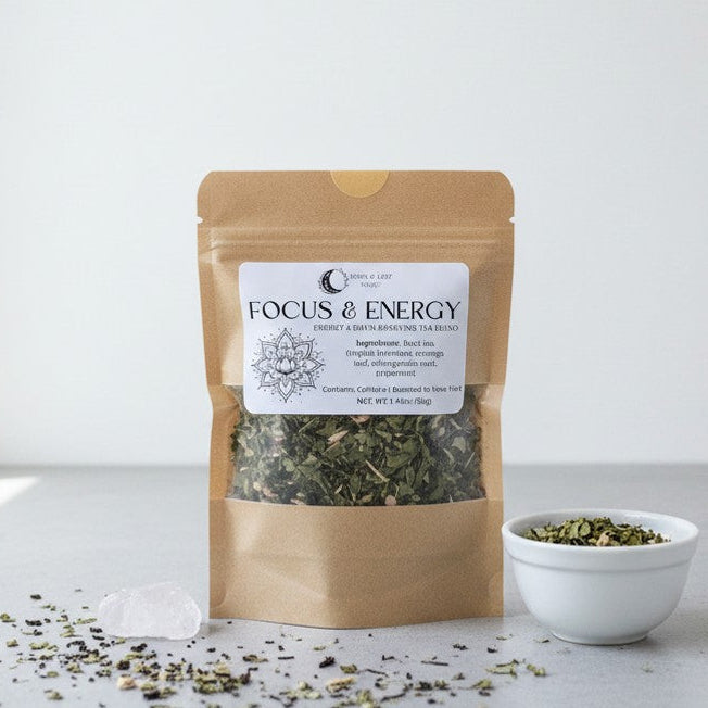 Tea package labeled 'Focus & Energy' with a small bowl of tea leaves on a light background