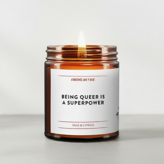 Candle in a jar with a label reading 'Being Queer is a Superpower' on a white background.
